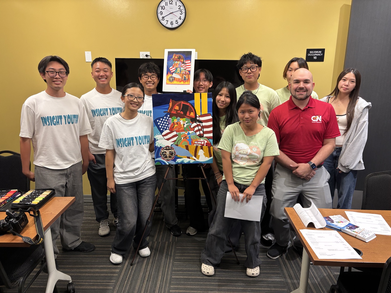 Chris with Insight Youth students displaying their artwork.